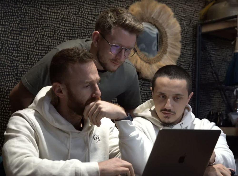 Charles et deux copy chiefs relisent un texte sur un ordinateur.