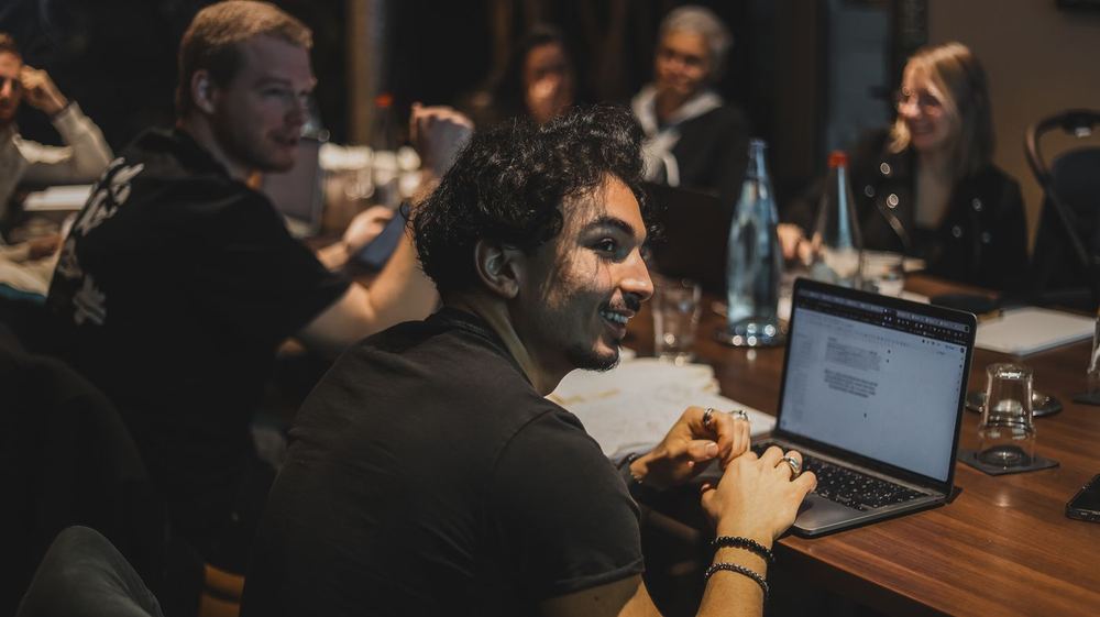 Un membre du Copy Camp sourit en écrivant sur son ordinateur.