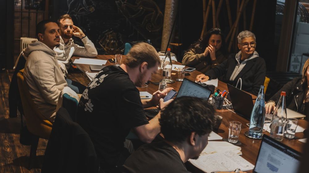 Des membres du Copy Camp travaillent autour d’une grande table en bois.